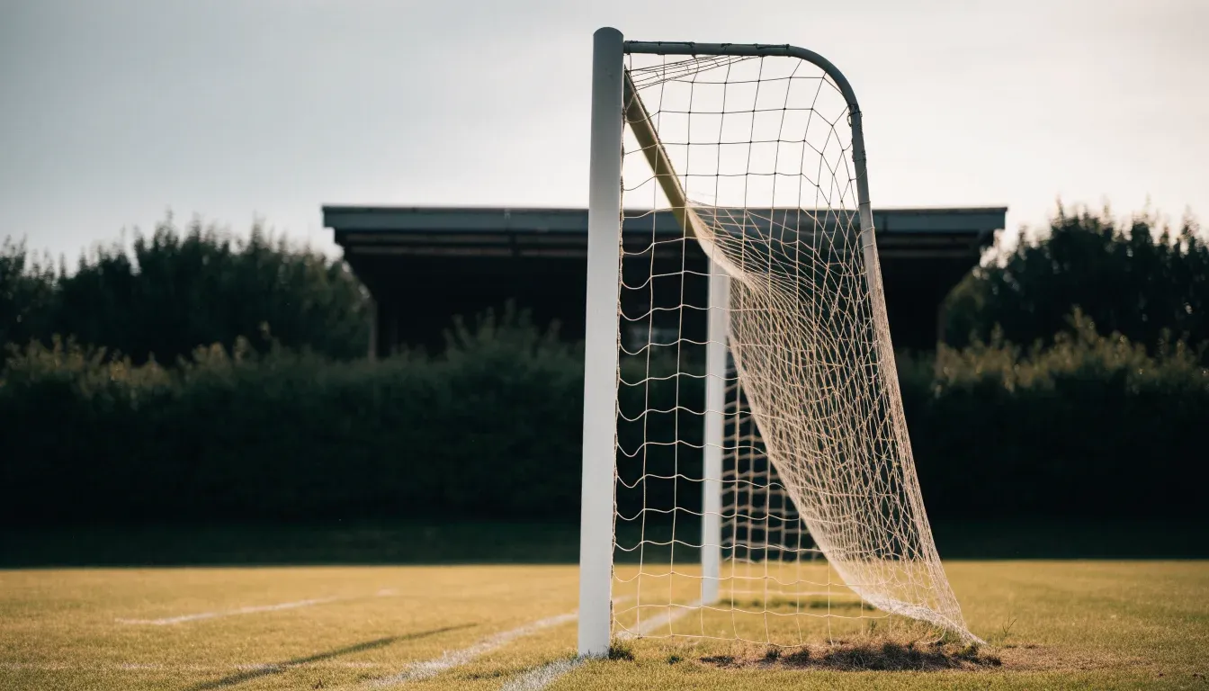 Ein Fussballtor mit locker hängendem Netz auf einem Trainingsplatz, das sich leicht im Wind bewegt.